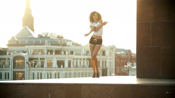 A Young Woman with Curly Hair and in Small Shorts Performing Attractive Dancing - Sunset