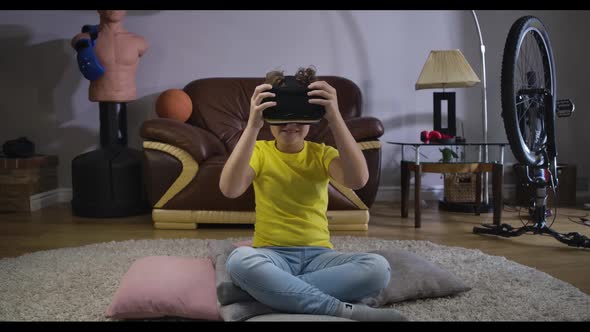 Portrait of Smiling Caucasian Boy in Casual Clothes Taking on VR Headset. Cute Child Trying on His