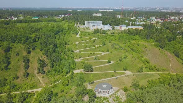 Green Hill with Path on Hairpin Curves on Nice Day Aerial