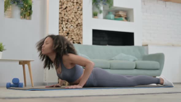 Young African Woman Doing Yoga on Yoga Mat at Home