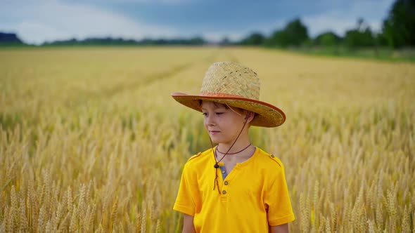 Boy in straw hat outdoors.