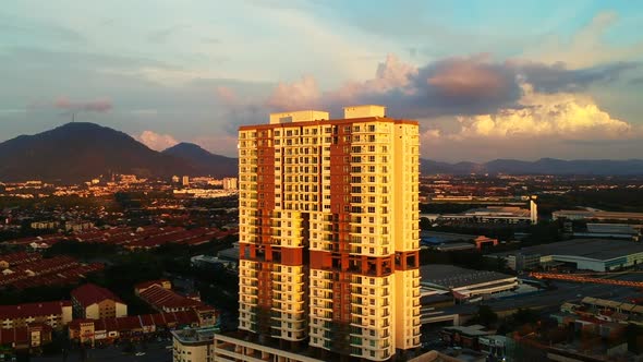 An aerial shot of high rise building surrounded by low rise homes during sunset.