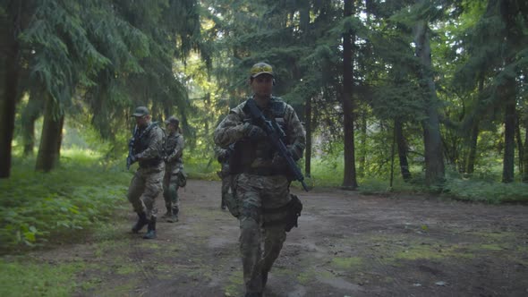 Detachment Commander Giving Arm Signal to Soldier in Forest at Dawn