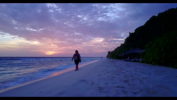 Female model suntans on idyllic lagoon beach break by blue lagoon and white sand background of the M