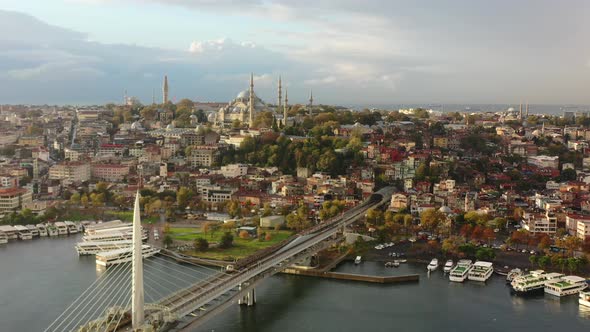 Wide aerial view a train crossing Halic Metro Bridge and the Bosphorus River on a colorful and vibra