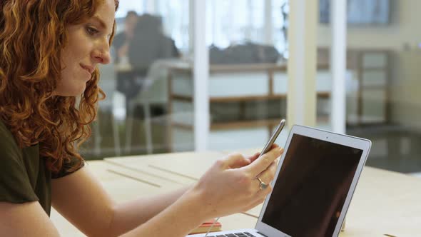 Businesswoman using mobile phone at desk 4k