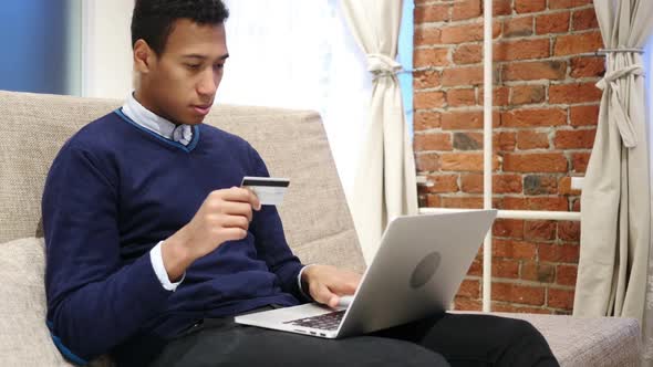 African Man Excited for Successful Online Shopping Transaction