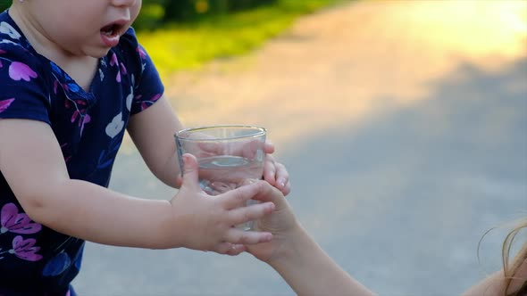 The Child Drinks Water From a Glass