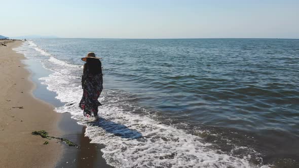 Camera Flying Over Woman Towards the Sea alt