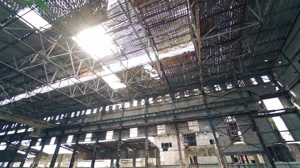 Ruined plant interior with pitted roof and the sun shines inside.