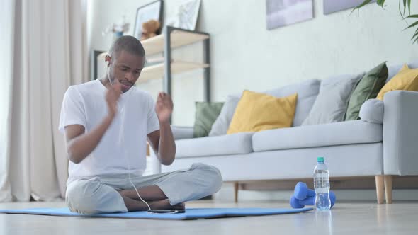 African Man Listening Music on Headphones and Meditating