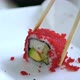 Lonely Sushi Roll in Tobiko Caviar is Taken with Wooden Chopsticks - VideoHive Item for Sale