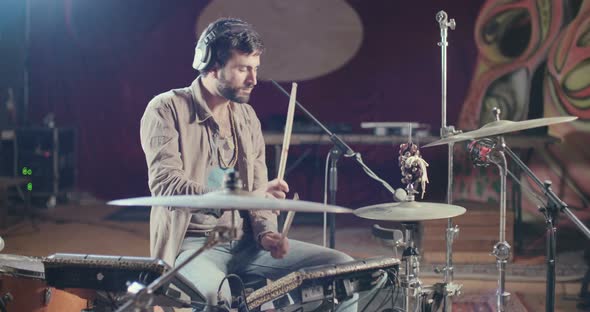 Drummer playing on electronic drum set in a recording studio