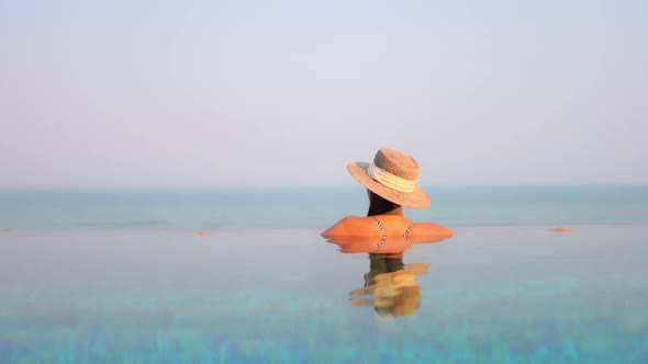 Young asian woman enjoy around outdoor swimming pool for leisure