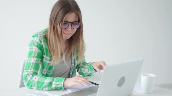 Woman Considers the Amount of Expenses for Purchases and Payment of Credits By Entering Information