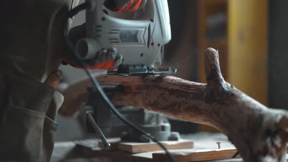 Woodworker cutting wood with fretsaw