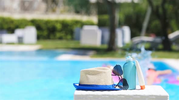 Suncream, Hat, Sunglasses Near Swimming Pool