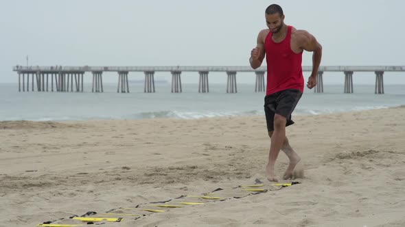 A young man doing speed and agility training on the beach.