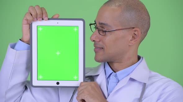 Face of Happy Bald Multi Ethnic Man Doctor Showing Digital Tablet