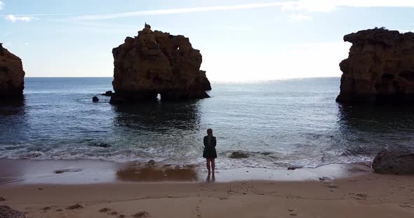 Woman in Beautiful Waving Dress Walking at the Empty Algarve Beach