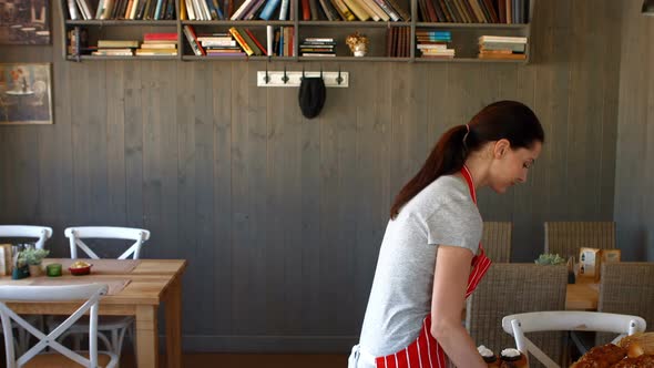 Portrait of female baker holding sweet food in tray