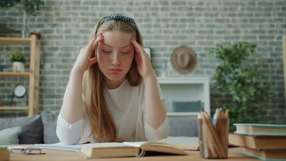 Tired Teenager Touching Head Feeling Headache Doing Homework in Apartment