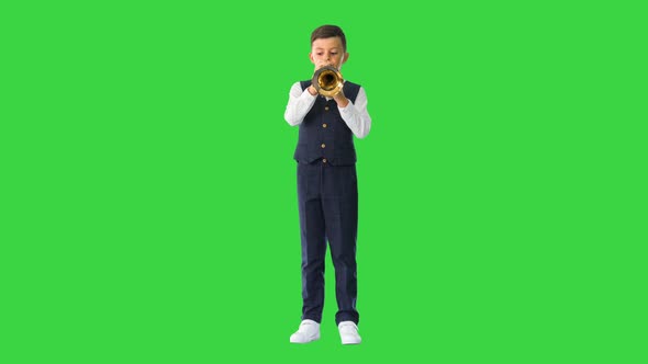 Concentrated Little Boy in a Bow Tie Blowing the Trumpet on a Green Screen Chroma Key