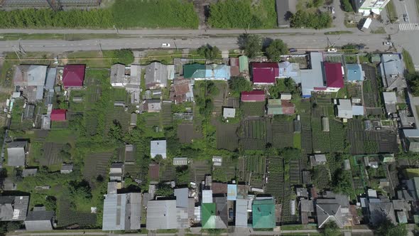 Aerial view of city with low houses, stadium and factory, summer, sunny day