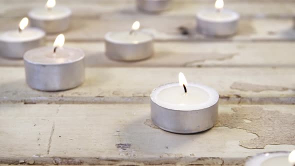 Burning candles on wooden plank