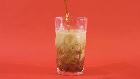 Ice cubes and cola in a swivel glass.