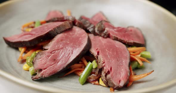 Close Up Grilled Vegetable Salad with Rare Medium Cooked Beef in a White Plate