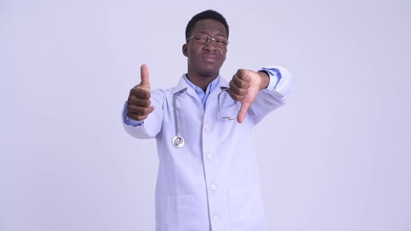 Young Confused African Man Doctor Choosing Between Thumbs Up and Thumbs Down