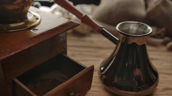 The Unrecognizable Person Taking Ground Coffee From an Old Coffee Grinder to Brassy Cezve