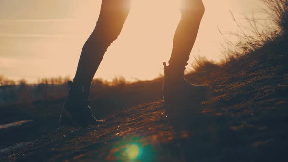 Active Female Tourist Wearing Leather Hiking Boots Reaches the Summit at Stunning Sunrise. Girl in