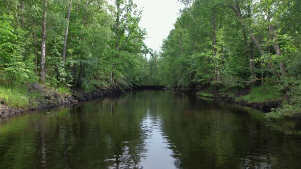 Drone flying slowly over Emån river, Sweden summertime