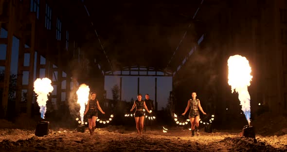 Four Women in Leather Clothes with Fire Dance and Show Fire Show a Man with a Flamethrower in the