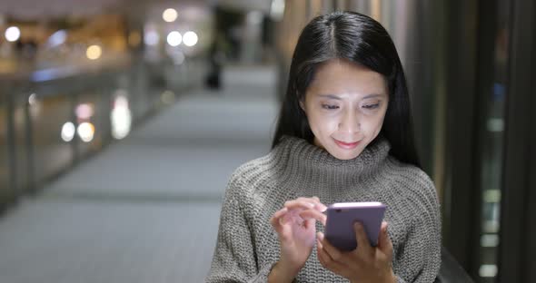 Business woman using mobile phone in the city at night