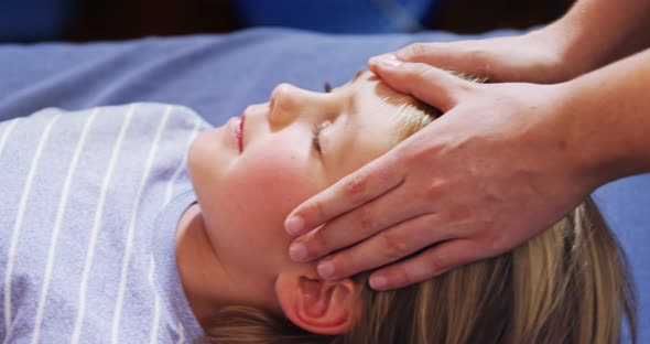 Physiotherapist giving head massage to a boy 4k