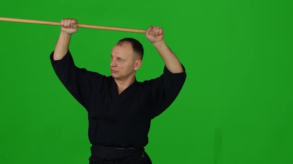 Masculine Kendo Warrior Practicing Martial Art with the Bamboo Bokken on Green Screen. CLose Up