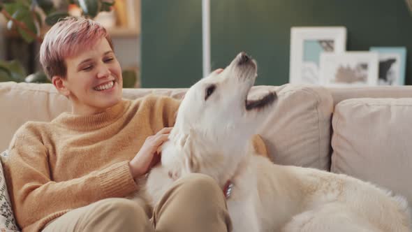 Female Owner Petting Dog on Sofa