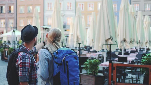 Back View of Young Tourists Couple Making Selfie on Smartphone in the City Center