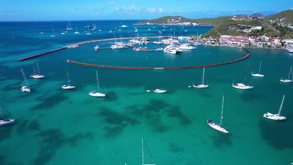 Aerial reveal of Marigot Marina in St. Martin with Caribbean blue water on a calm clear day.