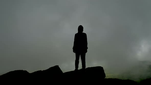 Silhouette of a Man on a Background of Gray Fog