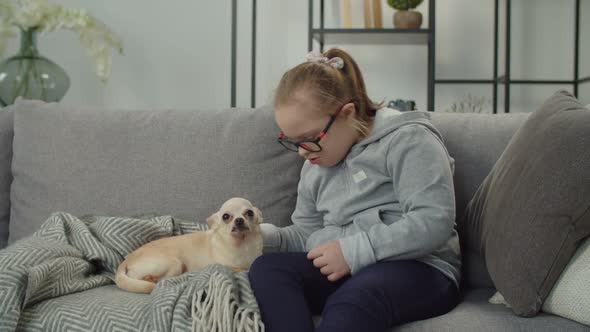 Cheerful Girl with Down Syndrome Relaxing with Pet Indoor