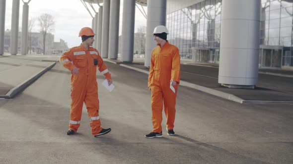 Two Construction Workers in Orange Uniform Giving High Five