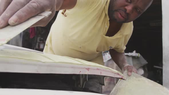 African man painting a car