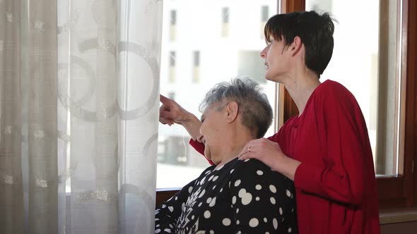 Mother and daughter looking something interesting out the window