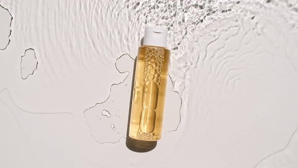 Cosmetic Bottle Vial on Water Surface with Drops