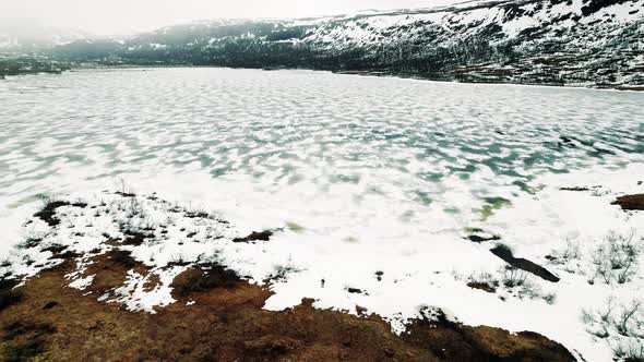 Aerial View Of Frozen Lake Isdalsvatnet Located In in Hordaland Fylke, Norway. Pedestal Up Reveal