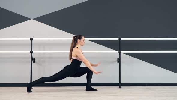 Woman Stretching Leg in Reverse Lunge Holding Handrial